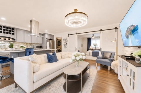 A spacious, open-concept living room featuring a large Smart TV with both Android TV and Roku for endless entertainment options.