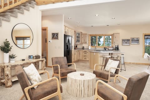 - Gather in this cozy sitting area with rustic wood accents and warm tones   - Open layout connects the living space seamlessly to the kitchen and dining   - Relax in comfortable armchairs that make conversation easy and inviting