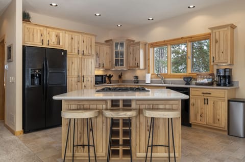 - Central kitchen island with seating for quick bites and casual dining   - Smooth countertop space for meal prep or entertaining guests   - Built-in wine rack keeps your favorite bottles close at hand