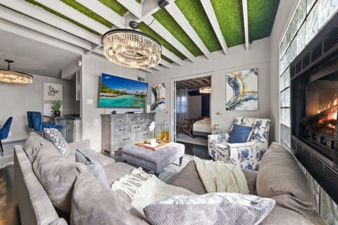 Relax in the spacious living room, complete with a plush sectional, a Smart TV for streaming, and a charming fireplace that adds a cozy touch to the space.