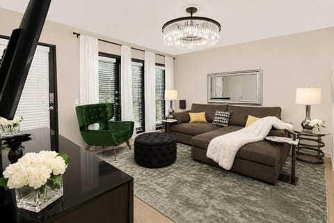 Modern, cozy living room with a spacious sectional, Smart TV, and elegant designer touches, perfect for relaxing after a day of exploring.