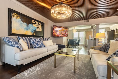 Contemporary lounge with bold art, ambient lighting, and custom furniture beneath a handcrafted wood ceiling — perfect for entertaining or relaxing.