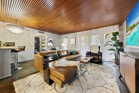 Spacious living room with a comfy leather sectional sofa and lounge plenty of space to entertain your guest, seamlessly extending the entertainment outdoors  