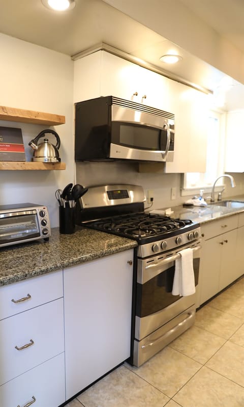 Kitchen from Dining Room showing toaster oven, tea kettle, stove, microwave,