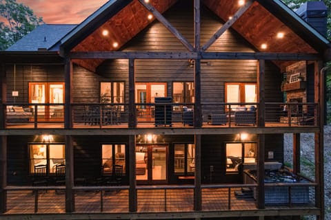 There are two levels of decks on the back of the house.  The back is surrounded by trees.  The top deck has a grill, dining area, large bed swing, and wood fireplace with seating area.  The lower deck has the 8 person hot tub and rocking chairs.
