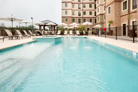 Large outdoor pool with lounge chairs and umbrellas.