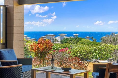 Oceanview private lanai with outdoor seating, lush tropical landscaping, and sweeping views of Kapalua's blue waters and island skies.