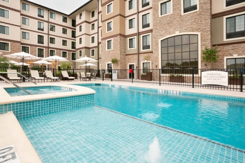 Outdoor pool with lounge chairs and umbrellas.