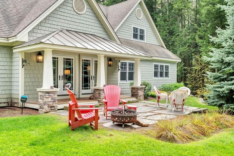 Stone patio with fire pit and Adirondack chairs, steps from the covered porch