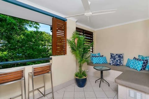 A leafy private balcony offers ample seating for guests to unwind outdoors under the gentle breeze of a ceiling fan.