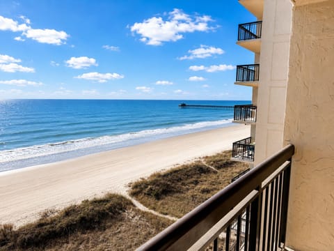 Oceanfront balcony scene: coffee with waves and a front-row sunrise.
