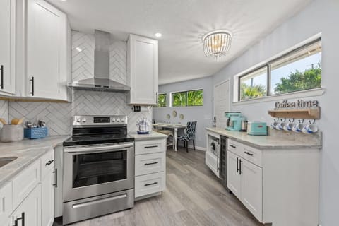 Step into a stunning, fully renovated kitchen featuring gleaming stainless steel appliances, luxurious granite countertops, and a fully stocked setup ready for cooking, coffee, and entertaining. The retro-series coffee bar adds a playful, stylish touch fo