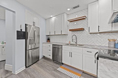 Step into a stunning, fully renovated kitchen with gleaming stainless steel appliances, high-end granite countertops, and a fully stocked setup—perfect for cooking meals, making coffee, and entertaining guests.