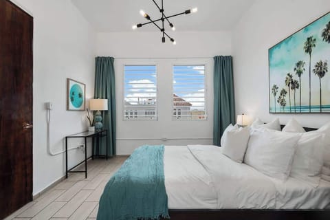 Comfortable queen sized bed in this spacious bedroom with high ceilings and street views.