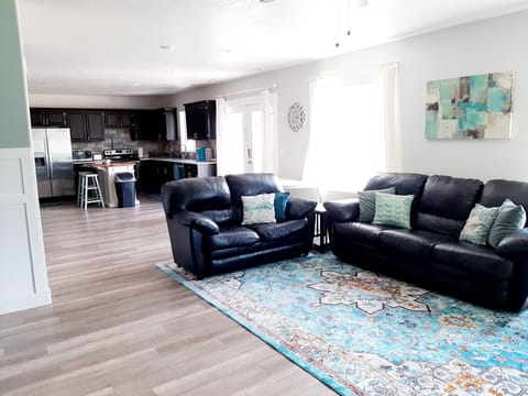 Both ends of large sofa recline. Living room open to kitchen and dining area.