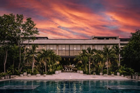 Sunset views over resort pools surrounded by lush tropical landscaping