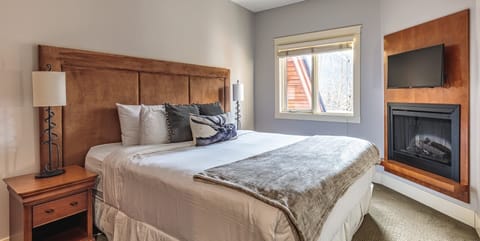 Studio living elevated with a huge king bed and fireplace.