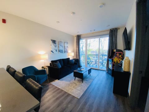 Living room with 60 inch smart tv, arcade game, JBL speaker and private balcony 