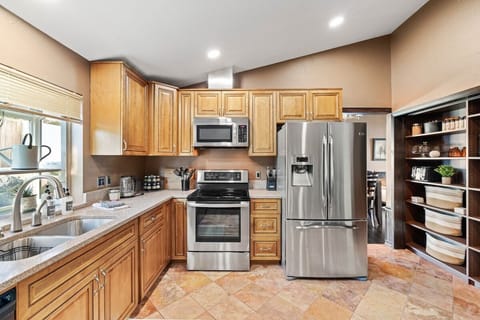 Experience the joy of cooking and entertaining in this spacious kitchen, fully stocked with everything you need for culinary creations. From top-of-the-line appliances to ample counter space and storage, this kitchen is a chef's dream come true