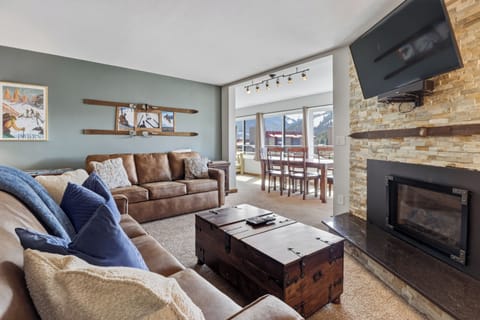Unwind in your cozy mountain retreat with comfortable seating, warm fireplace, and stunning alpine views from your private balcony.