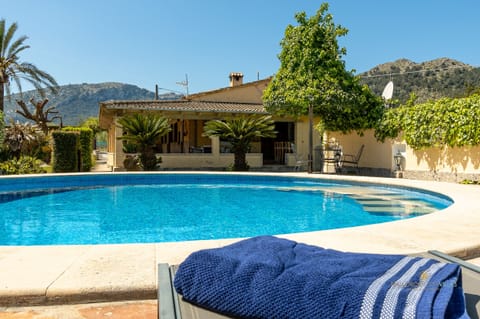 Private swimming pool at a Mallorcan villa surrounded by garden areas, with sun terrace and open mountain views.