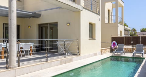 Private swimming pool next to the terrace at Villa Albufera, surrounded by sun loungers and modern outdoor areas, perfect for relaxing and enjoying the Mallorcan sun.
