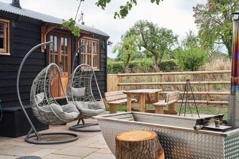 The egg chairs, outdoor dining table and wood-fired Swedish Hikki hot tub at The Hangout Hut, Worcestershire