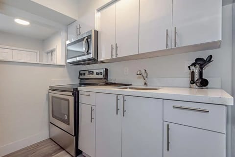 Featuring white quartz countertop and kitchen cabinet design