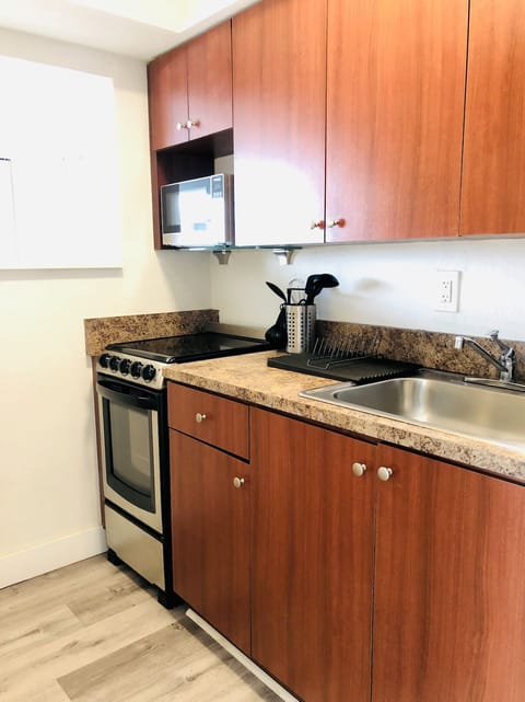 Kitchen with sink, flat stove and above flat range microwave.