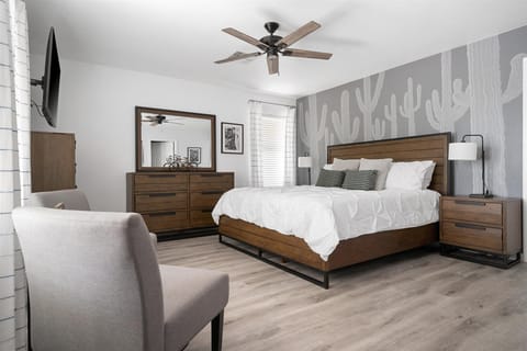 The beautiful desert mural of saguaros behind the comfortable king bed.