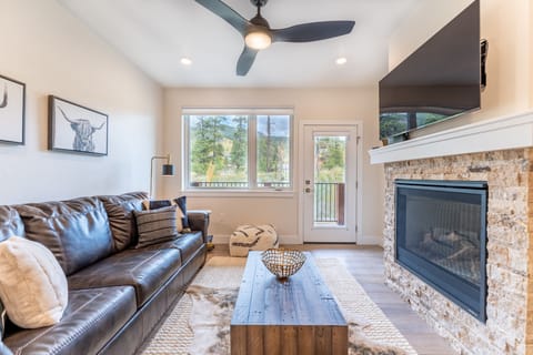 Sink into plush leather seating by your cozy stone fireplace, where natural light streams through picture windows.