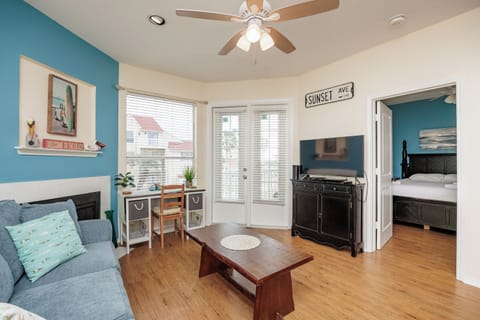 Unwind in your cheerfully decorated living space with coastal touches, comfortable seating, and warm wood floors that invite relaxation.