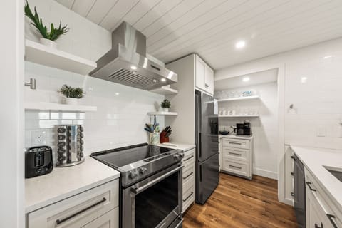 This gourmet kitchen is fully stocked and features new stainless steel appliances.