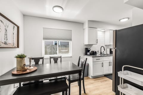 Kitchen dining table features 4 chairs. Window has blinds for privacy / light blocking