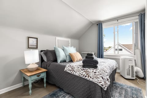 The guest bedroom features a queen-size bed adorned with cozy sheets and pillows for your ultimate comfort.