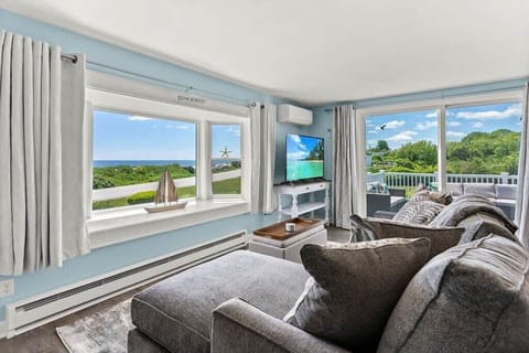 Open kitchen & living room with sleeper sofa, 50" smart TV, high-efficiency mini-split for AC/heat, and stunning views of the ocean.