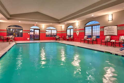 Indoor pool with blue water and lounge seating.