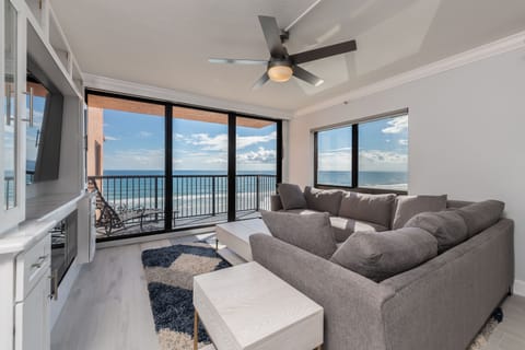 Bright oceanfront living room with sweeping beach views and large windows that fill the space with natural light.
