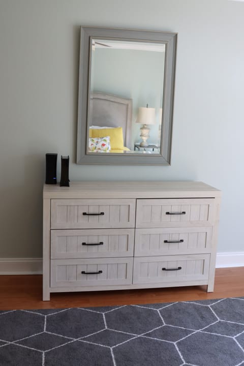 Queen guest room has dresser and mirror.