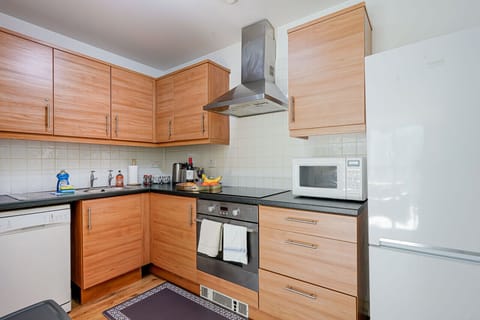 A fully equipped kitchen with fridge freezer, oven, stove, microwave, dishwasher, kettle, toaster, cookware, tableware, and utensils all provided