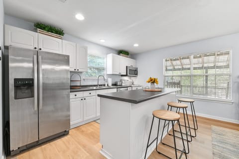 Stocked kitchen with bar top seating for 3