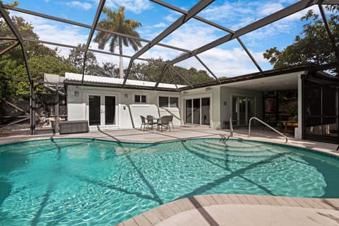 [Backyard] Screened-in heated pool with lounge area.
