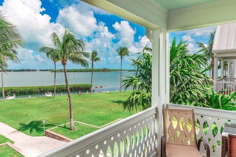Relax on the private covered porch while enjoying palm-framed views across the lawn toward the beautiful Gulf of Mexico.