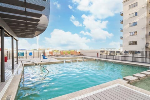 Rooftop Pool • Lounge Chairs & City Skyline