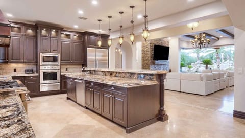 Large full kitchen next to entertainment room w/ two large luxury couches