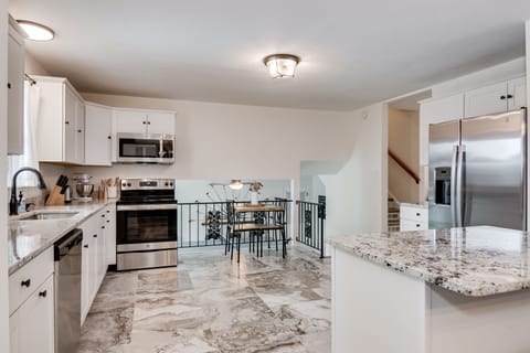 Full sized and fully stocked kitchen with small seating area.