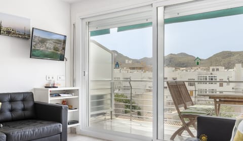 Bright living room with access to the balcony and open mountain views in Port de Pollença