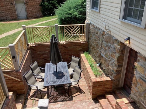 Brick patio, table and 8 chairs, main entrance door on the right