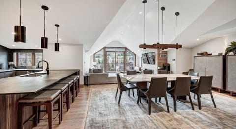 Gather around the dining table in a beautifully designed space, seamlessly integrating the kitchen and living area, with access to breathtaking views.