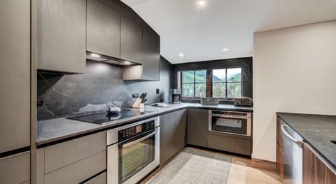 The modern kitchen boasts sleek finishes and state-of-the-art appliances, making it an ideal space for culinary creations amidst alpine elegance.
